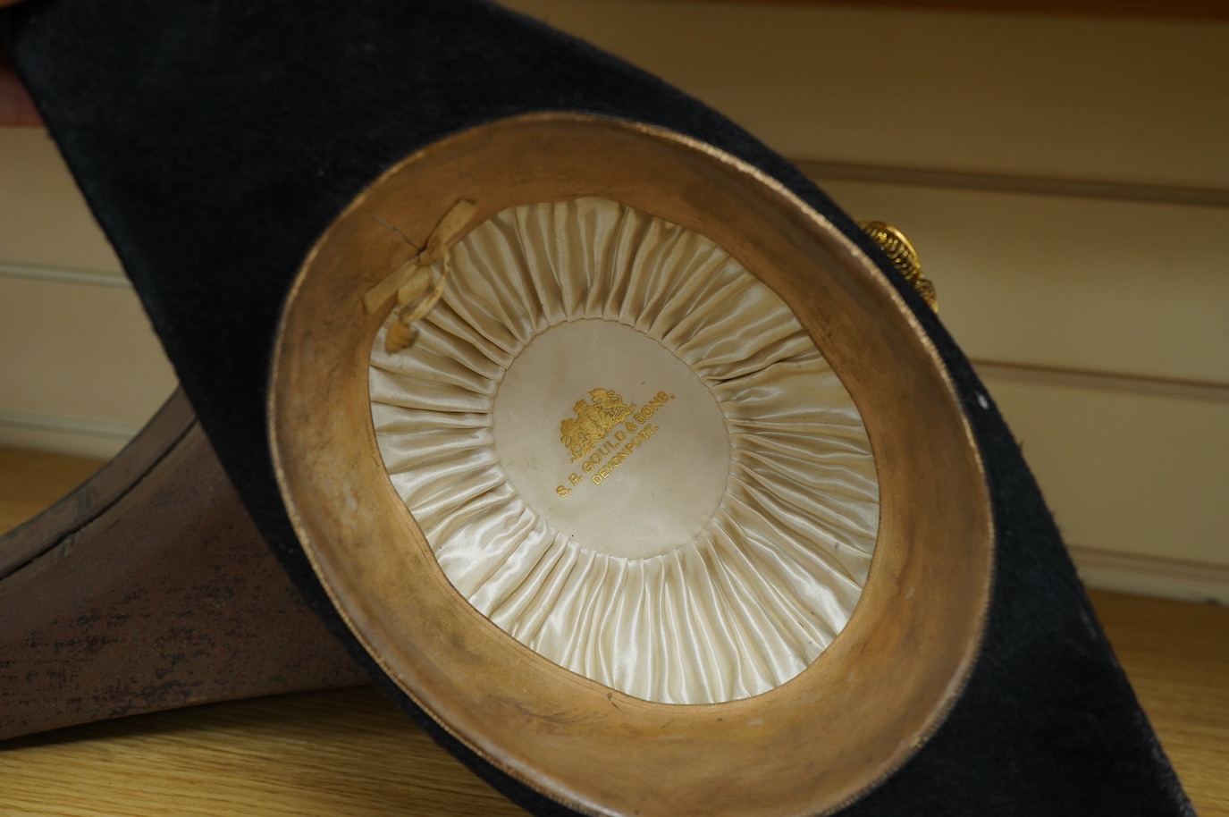 A Naval Lieutenant's bi-corn hat, in its tin case, with applied plaque for D. Donavon R.N. Condition - fair, with general surface rust to the case.